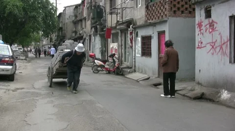 Worker carrying heavy bricks through Shanghai backstreets, China Video stock 7747350