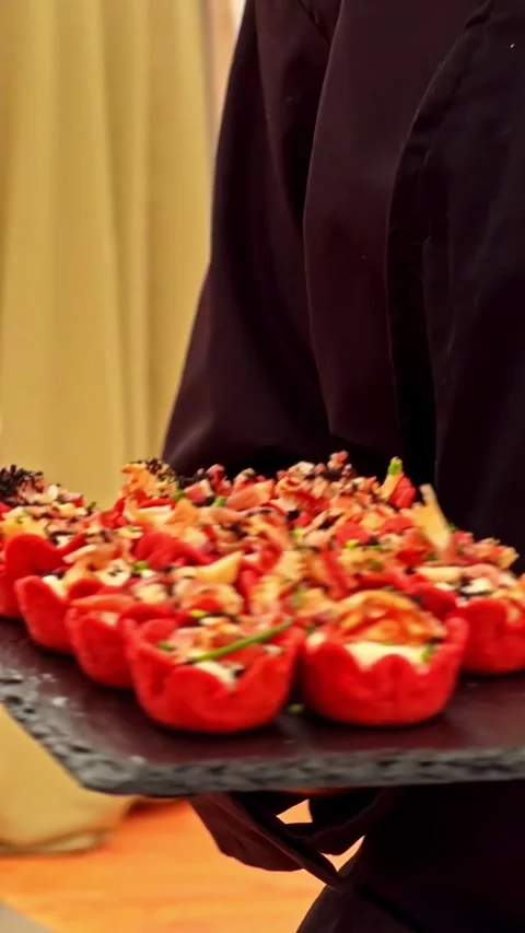 Worker Carrying Tray of Savory Appetizers During Outdoor Catering Event Stock Footage 336781090