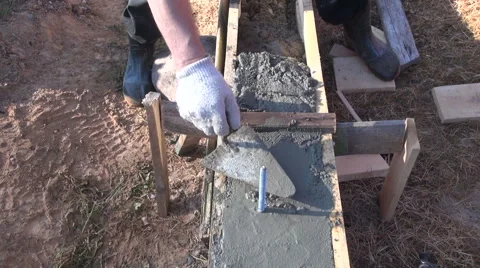 Worker cementing foundation with trowel Stock Footage 63656230
