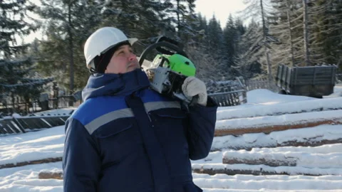 Worker with chainsaw on shoulder looking around in winter forest 库存影片 86929662