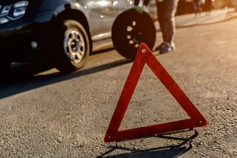 Worker changes a broken wheel of a car. The driver should replace the old wheel Stock Photos
