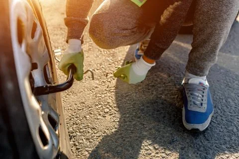 Worker changes a broken wheel of a car. The driver should replace the old wheel Stock Photos