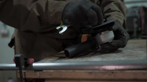 A worker changes the saw blade to a grinding blade on a angle grinder. Vídeos de archivo 312313960