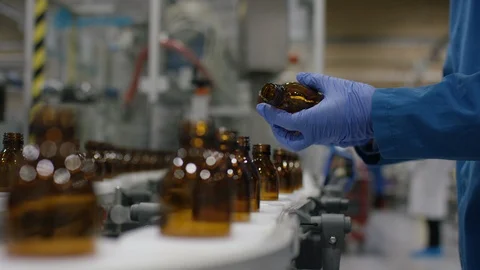 Worker checking empty bottles on production line in cosmetic factory Stock Footage 107980091