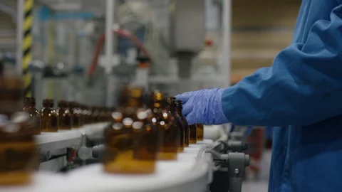 Worker checking empty bottles on production line in cosmetic factory Stock Footage 107980282