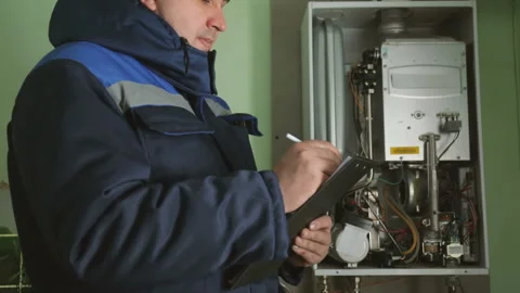 Worker checking gas-fire boiler Stock Footage 87762171