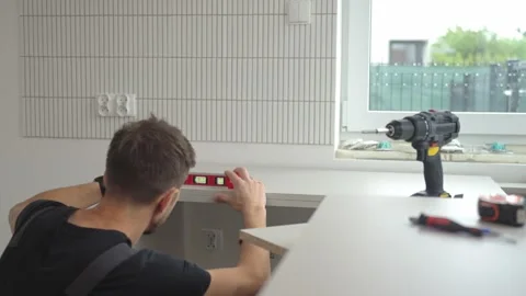 Worker checking kitchen countertop level with spirit level tool Stock Footage 310894325