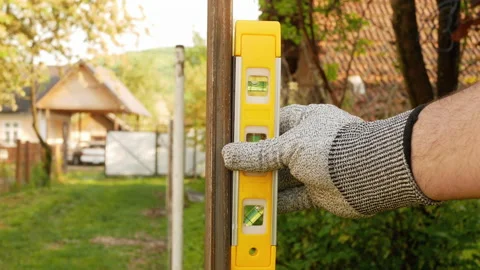 Worker checking level of the square tube with the bubble level tool. Stock Footage 154409115