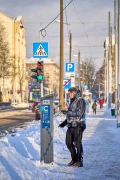 Worker checking parking ticket machine on the street in winter Stock Photos