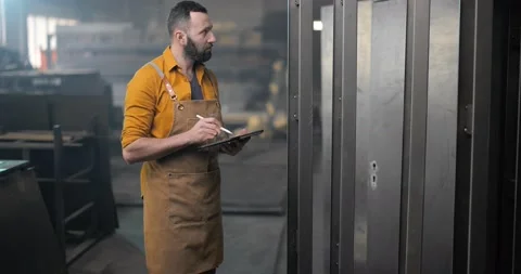 Worker checking the quality of metal products with a digital tablet Stock Footage 147286357