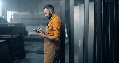 Worker checking the quality of metal products with a digital tablet Stock Footage 147287391