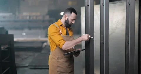 Worker checking the quality of metal products with a digital tablet Stock Footage 147288707