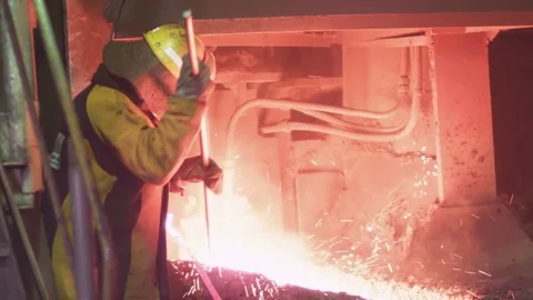 A worker is checking the quality of molten metal Stock Footage 72610658