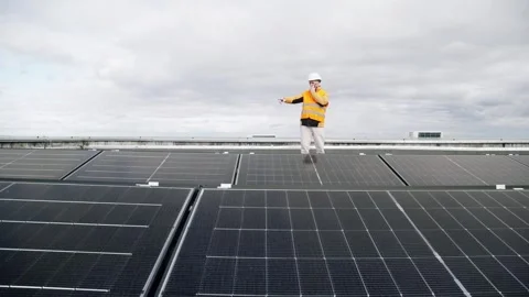 Worker checking rooftop solar panels with walkie-talkie. Vídeos de archivo 330873745