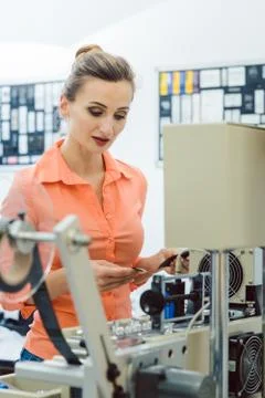 Worker checking textile label fresh from the printing machine Stock Photos