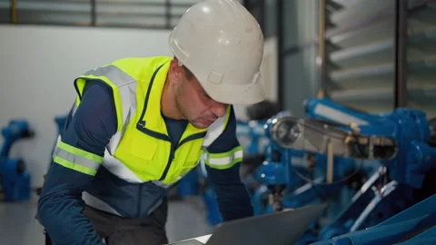 Worker checks robot systems with a laptop Stock Footage 344919639