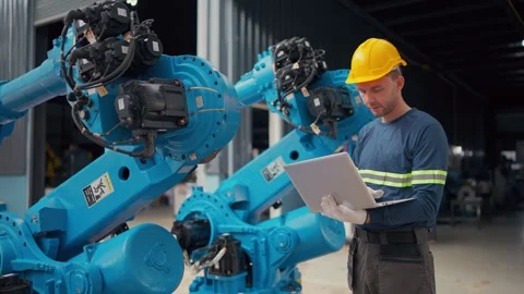 Worker checks robot with tablet, focused and attentive Stock Footage 340984348