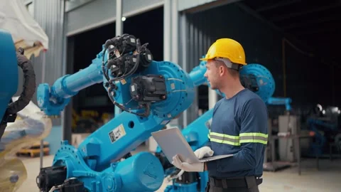 Worker checks robot with tablet, focused and attentive Stock Footage 340987763