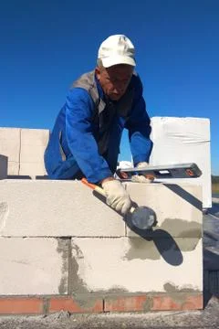 The worker checks the wall of gas blocks by a leveler Foto stock