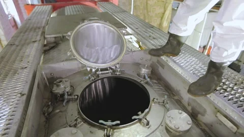 A worker in chemical protection closes the hatch on a truck tank. A worker in a Stock Footage 169444190