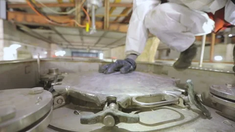 A worker in chemical protection opens a hatch on a truck tank. A worker in a Stock Footage 169238367