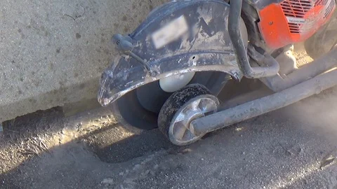 Worker with circular machine cutting through concrete or tarmac road the pavi Stock-Footage 100013477