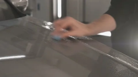 Worker clean car body with blue clay for cleaning before installing protective Stock Footage 157239356