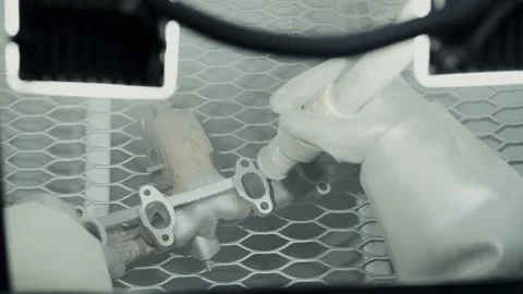 Worker cleaning and removing rust from car turbine turbocharger using a Stock Footage 281582464