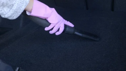 A worker is cleaning the car back with a vacuum cleaner Stock Footage 95652557