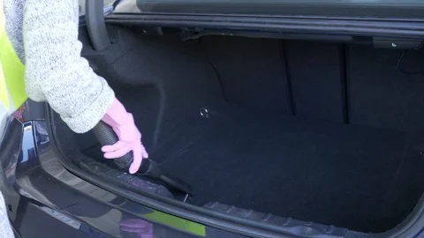 A worker is cleaning the car back with a vacuum cleaner Stock Footage 95652609