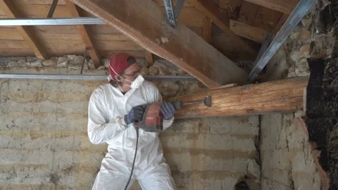 Worker Cleaning Up Dead Wood From the Framework of a House before Stock Footage 203832156