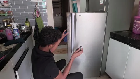 Worker cleaning an empty refrigerator in the kitchen. Stock Footage 335627089