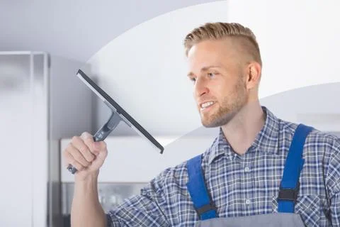 Worker Cleaning Glass Window With Squeegee Foto stock