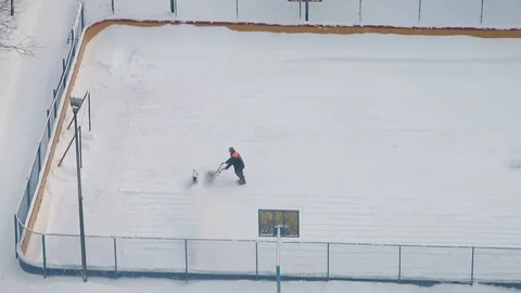 A worker cleaning ice rink after heavy snowing Stock Footage 107533943
