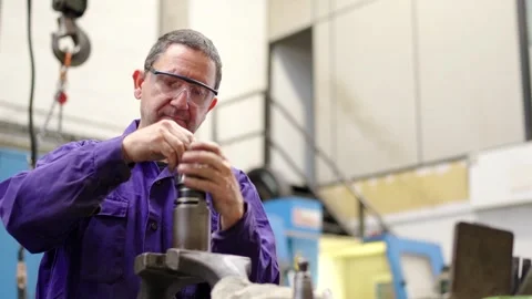 Worker cleaning an industrial machine in a cnc factory Stock Footage 258805530