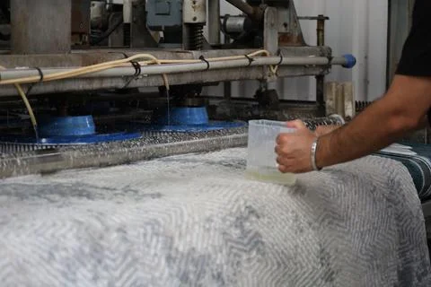 Worker cleaning patterned carpet with industrial rotary scrubbers inside Stock Photos