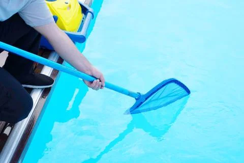 Worker cleaning the pool. Automatic pool cleaners. Stock Photos