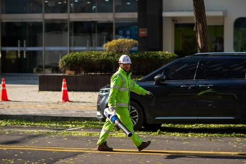 Worker Cleaning Sidewalk with Leaf Blower Stock Photos