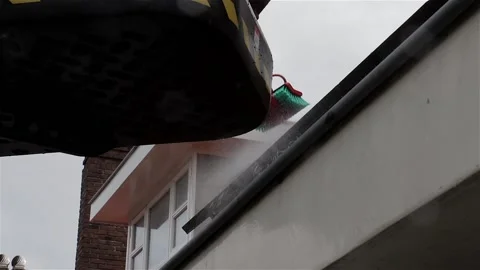 Worker cleaning solar panels on a slanted roof from a crane Stock Footage 135655572