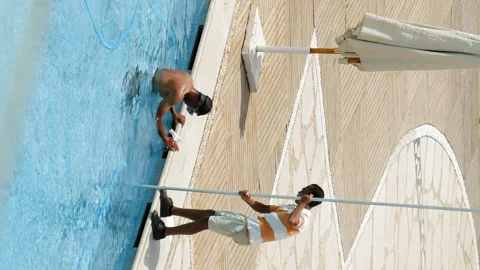Worker is cleaning the water pool with brush Stock Footage 91161031