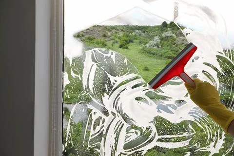 Worker cleaning window with squeegee, closeup. View through clear glass on .. Stock Photos