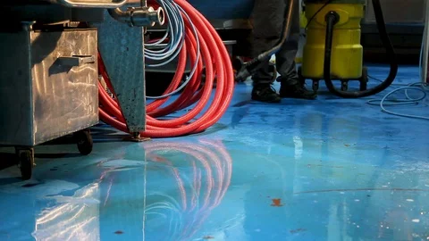 A worker cleans the blue floor economic vacuum cleaner in the winery Video stock 99106491