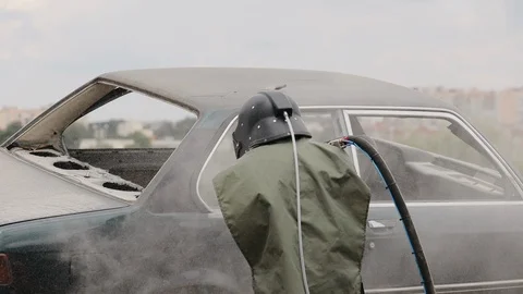 The worker cleans the elements of the car body by sanding Stock Footage 128263125