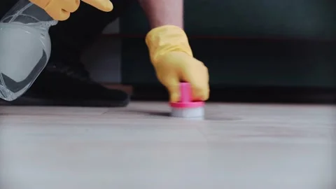 A worker cleans the floor with detergent using a pink brush and yellow . Stock Footage 146264528