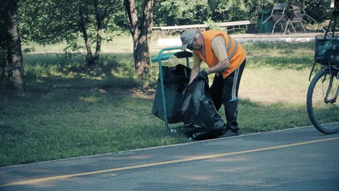 Worker cleans garbage in the city Park on a summer day Stock Footage 111763672