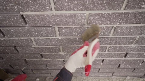 The worker cleans the joints between the bricks with a brush. Stock Footage 162508518