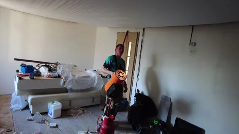 Worker cleans room filled with trash and clutter in an abandoned space this Sept Stock-Footage 332065701