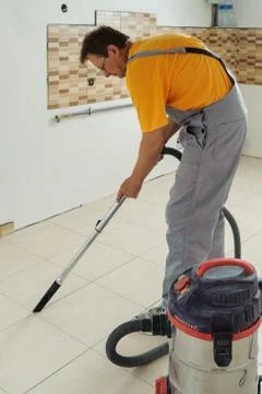 Worker cleans seams between tiles Stock Photos