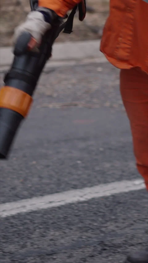 A worker clears the road of branches and leaves Stock Footage 272479692