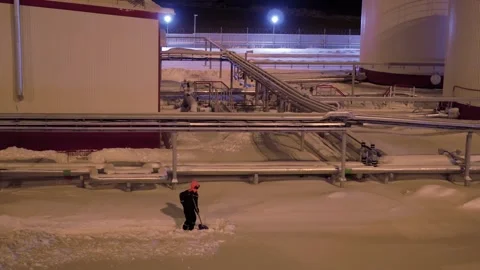 Worker clears snow. Winter scene with worker in industrial area depicts cold Stock Footage 280810366